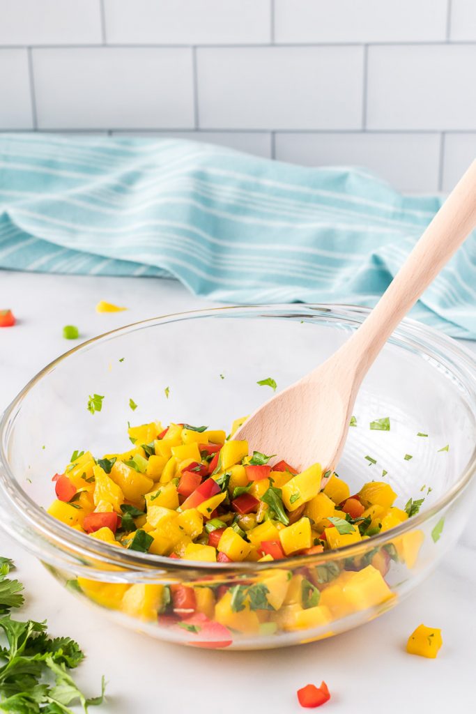 Mixing a bowl of mango salsa 