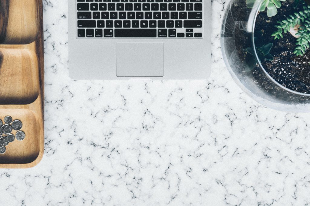 A laptop, some loose change, and a potted plant