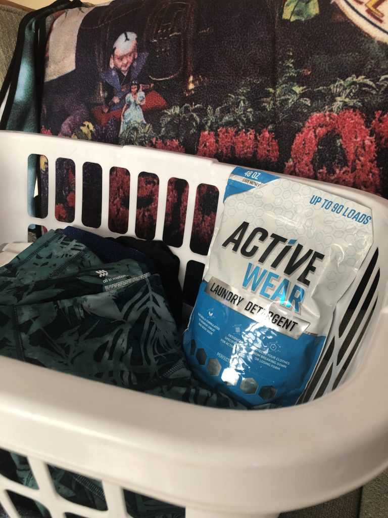 A bag of Active Wear Detergent in a laundry basket 