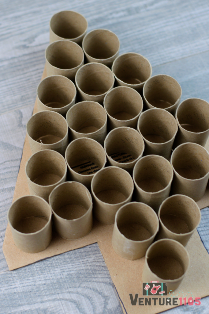 Toilet paper rolls on a cardboard that is shaped like a tree