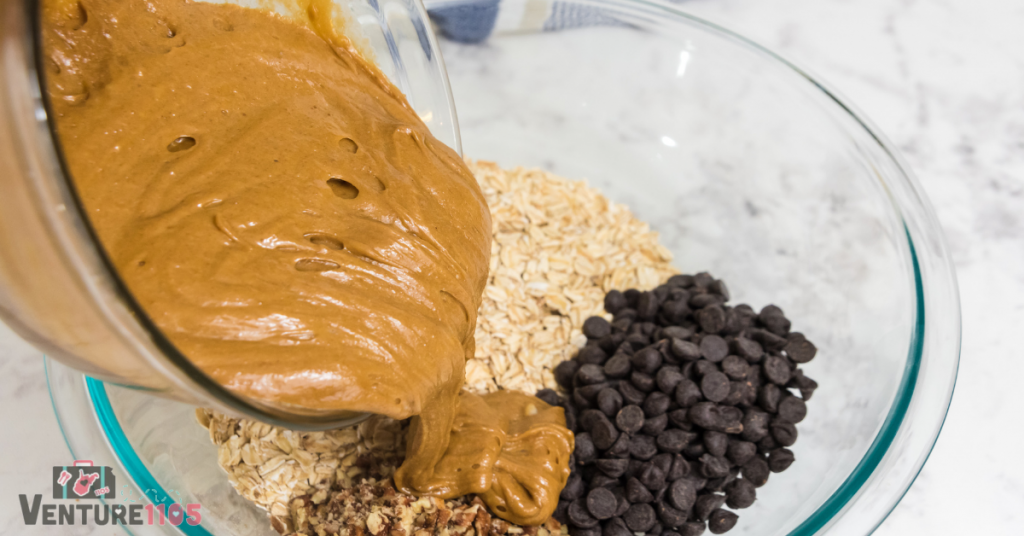 Adding peanut butter mixture to the oatmeal and chocolate chips 