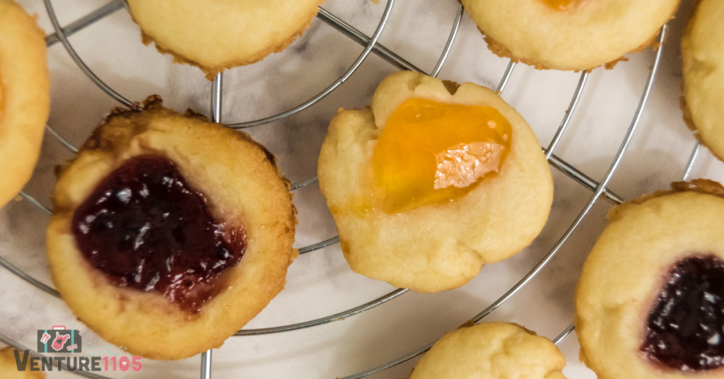 A close up of thumbprint cookies cooling on a rack 