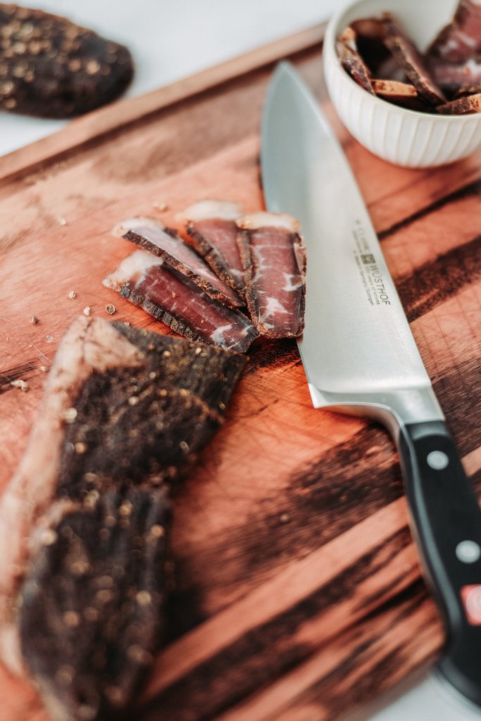 Dried meat with a knife on a cutting board