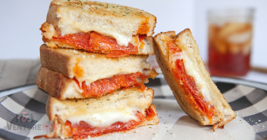 Grilled cheese stacked on a black and white plate