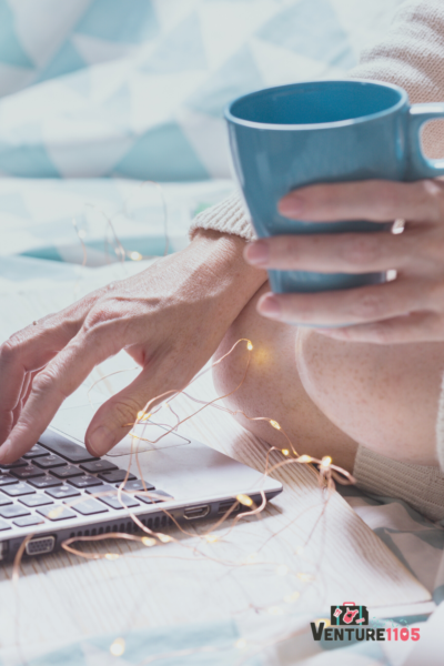 A lady with a blue coffee cup using her laptop