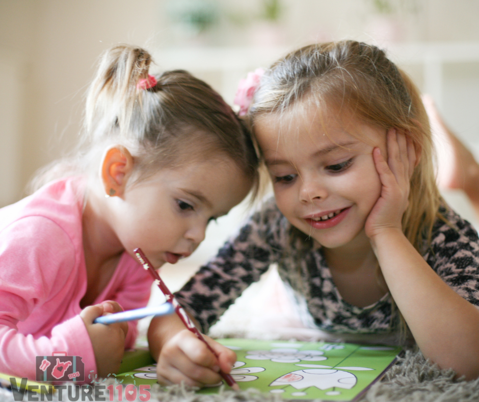 Two little girls coloring in a coloring book