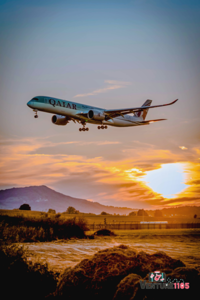 an airplane in the sky at sunset