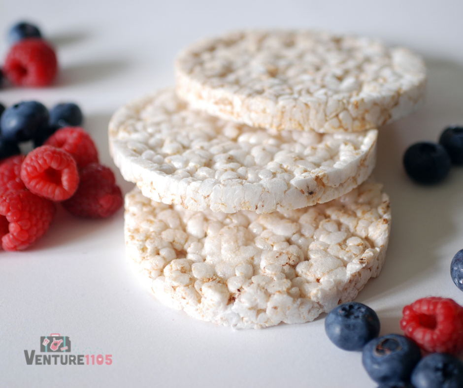 3 rice cakes with blueberries and raspberries around it 