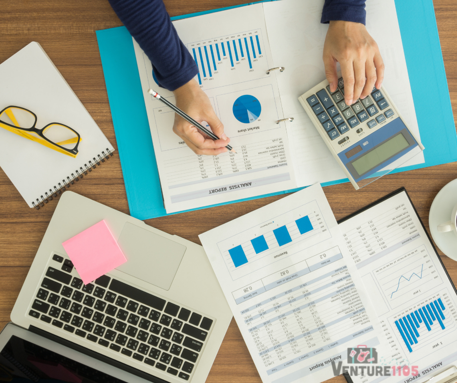 A woman doing accounting with a calculator and papers 