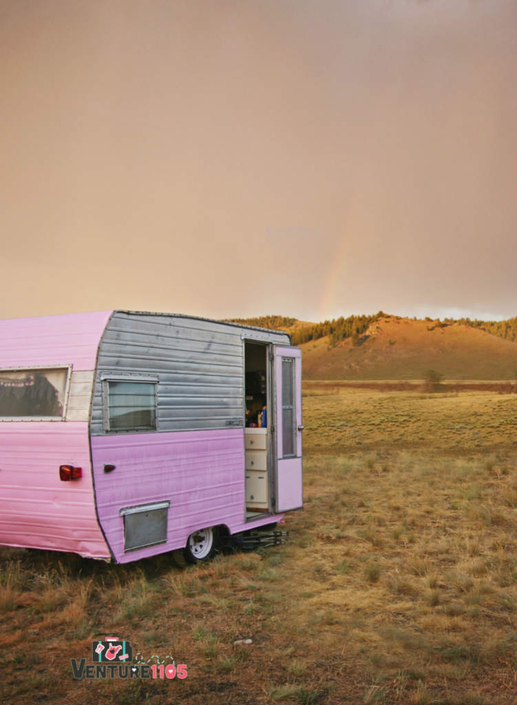 A pink and grey camper trailer at sunset 