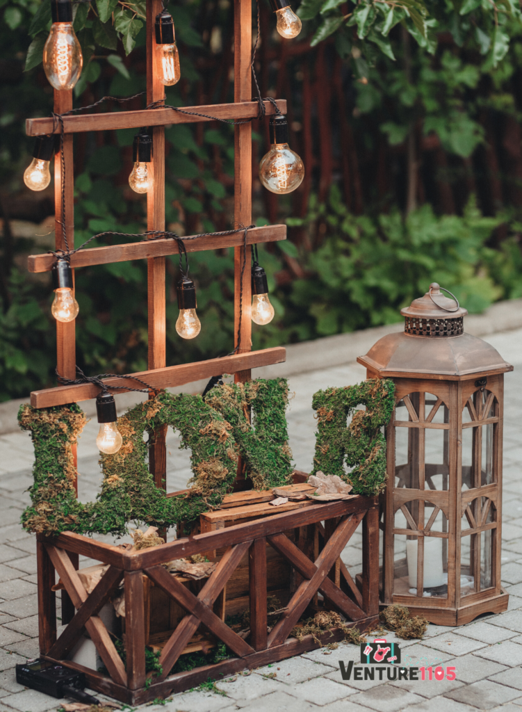 The word LOVE spelled out with greenery, on a table outside at a wedding 