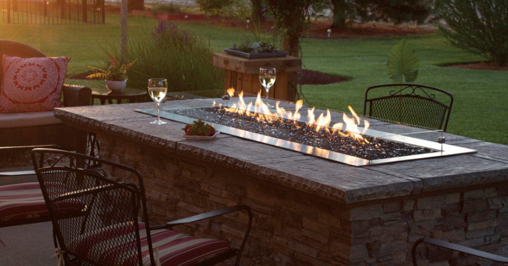 An outdoor electronic fire pit that is built into a patio dining table 