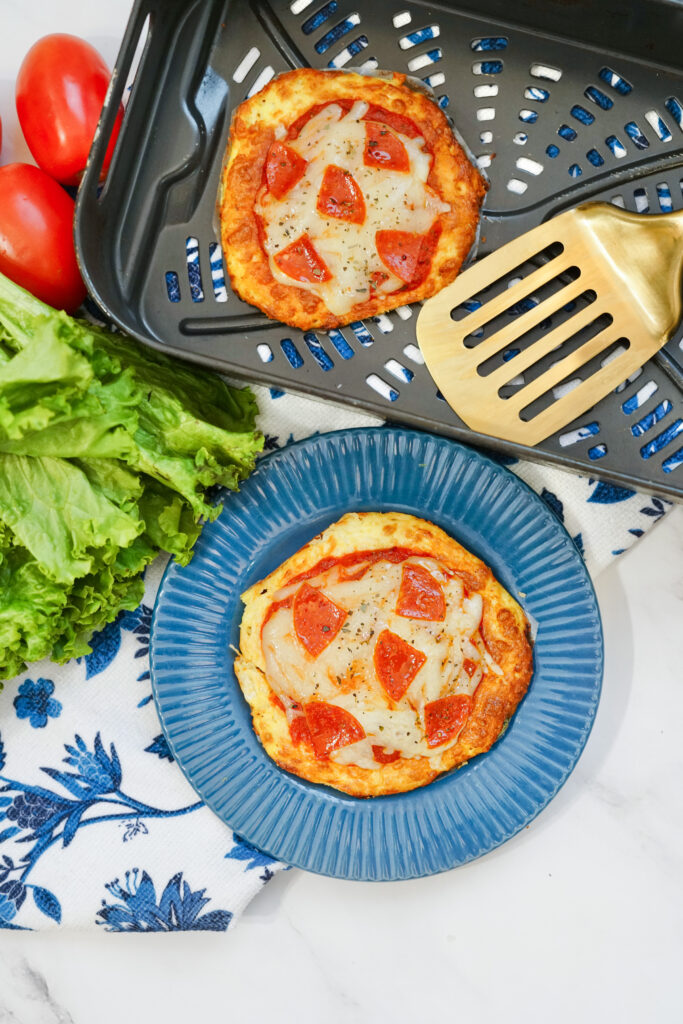 A single serving keto air fryer pizza on a blue plate 