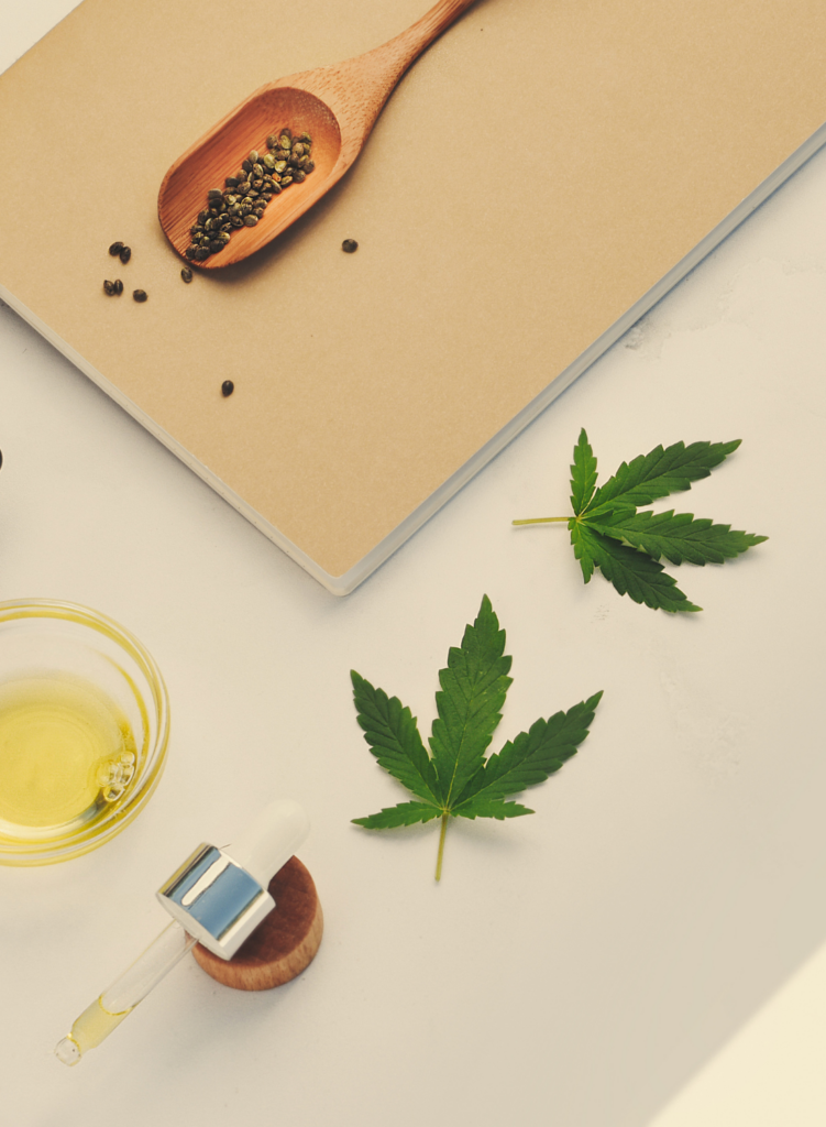 Hemp seeds, CBD oil, and some marijuana leaves 