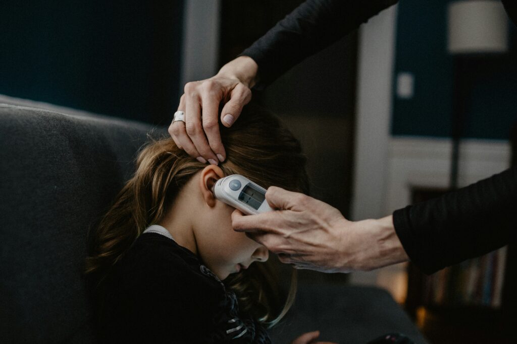 A girl getting her temperature checked 